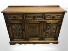 A reproduction carved oak linen fold sideboard,