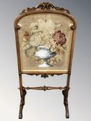 A Victorian carved walnut tapestry fire screen, height 104 cm.