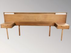 A 20th century G Plan teak headboard, incorporating two bedside tables fitted with drawers,