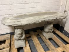 A rustic concrete garden bench on squirrel supports,