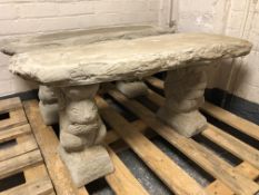 A rustic concrete garden bench on squirrel supports,