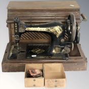A Singer hand sewing machine in box.