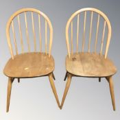 A pair of Ercol elm and beech spindle back dining chairs.