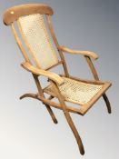 A 20th century folding chair with caned seat and back rest