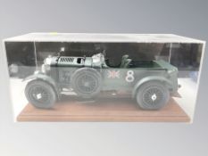 A plastic scale model of a 1930 Bentley, on wooden plinth, under perspex cover, length 39 cm.