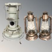 An Aladdin enameled metal greenhouse heater, height 54 cm, together with a pair of hurricane lamps.
