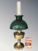 A brass Aladdin oil lamp with green glass shade and clear chimney, height 61 cm.