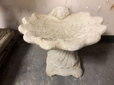 A concrete shell garden bird bath,