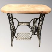 A cast iron Singer treadle sewing machine base with pine top, width 77 cm.