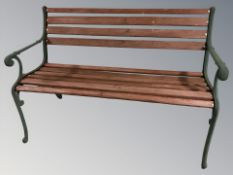 A painted cast metal and teak garden bench, width 123 cm.