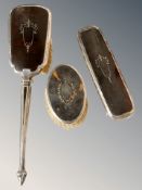 Three silver-mounted tortoiseshell dressing table brushes.