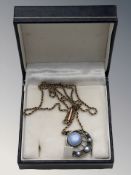 A Scandinavian silver and enameled circular pendant upon a 9ct gold chain.