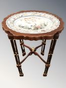 A reproduction occasional table with inset porcelain top,