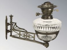 A Victorian oil lamp with brass mounting bracket, length 38 cm.