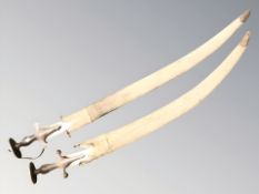 Two Indian Tulwar swords, in sheathes, longest 97 cm overall.