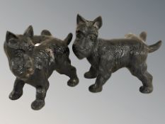 Two painted metal figures of scottie dogs.