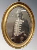 A gilt framed portrait photograph of a figure in military dress,