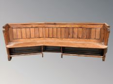 A Victorian pitch pine curved church pew, total length 230 cm.