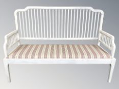 An early 20th century painted bench with striped cushion, length 153 cm.