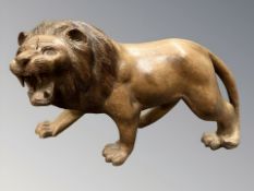 A carved hardwood figure of a roaring lion,