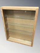 A pine single door cabinet with glass shelved interior, width 56 cm.