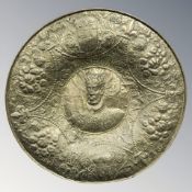 A large embossed brass charger, diameter 97 cm.