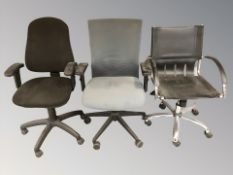Three various desk swivel armchairs.