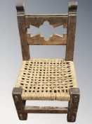 An early 20th century oak child's chair with rattan seat, height 55 cm.