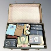 A vintage luggage case containing assorted volumes.