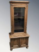 An early 20th century walnut and satinwood inlaid double door low cabinet with glazed cabinet above,