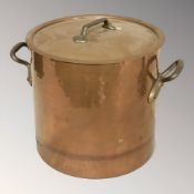 A copper and brass twin handled cooking pot, height 31 cm.