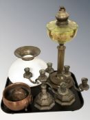A brass oil lamp with green tinted reservoir and opaque shade,