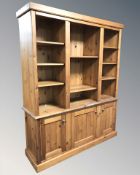 A modern pine open bookcase fitted with cupboards,