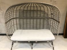 A woven plastic garden canopy seat / day bed, 147 cm W x 80 cm D x 140 cm H.