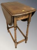 A reproduction oak drop leaf table,