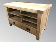 A modern oak entertainment sideboard fitted shelves and drawer, 110 cm x 50 cm x 69 cm.