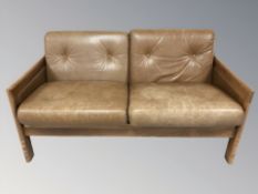 A late 20th century Danish wooden framed two seater settee with tan buttoned leather cushions,