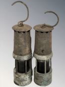 Two antique miner's lamps in weathered condition.