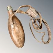 A glass powder flask, covered in stitched chestnut-brown leather with sling, the flask 24cm long.