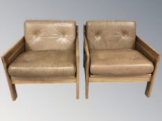 A pair of late 20th century Danish wooden framed armchairs with tan buttoned leather cushions,
