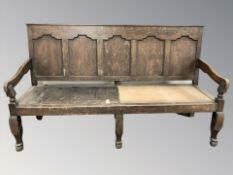 A late 18th / early 19th century panelled oak settle, 181 cm W x 63 cm D x 103 cm H.