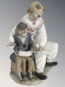 A Nao figure of two clowns with a squeeze box, height 31 cm.