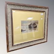 A 20th century colour print depicting a coastal view, 25 cm x 15 cm, in a decorative two tone frame.