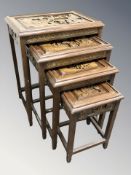 A set of four oriental carved hardwood occasional tables, width 50 cm.