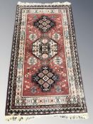 A machine made rug of Persian design, 213 cm x 111 cm.