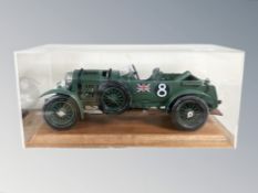 A plastic scale model of a 1930 Bentley, on wooden plinth, under perspex cover, length 39 cm.