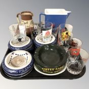 A group of whisky glasses with advertising, further ash trays, two jugs.