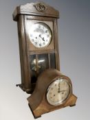 An early 20th century oak wall clock, with pendulum and key, length 63 cm,