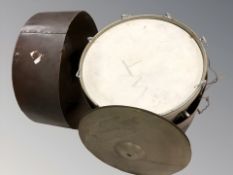 A large drum in carry case and a cymbal.