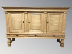 A Danish blond oak triple door sideboard,